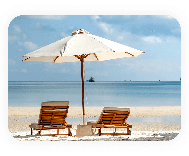 Two chairs on the beach under a beach umbrella