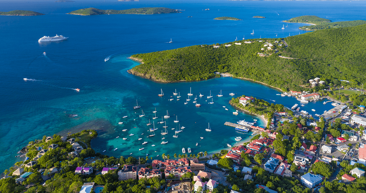 Arial view of a bay with sail baots and a surrounding city