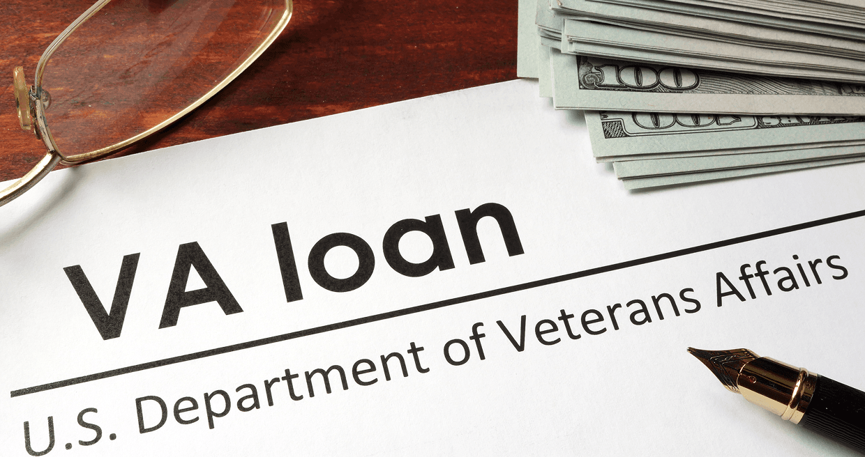 VA loan document on a table with a pen, glasses, and stack of money